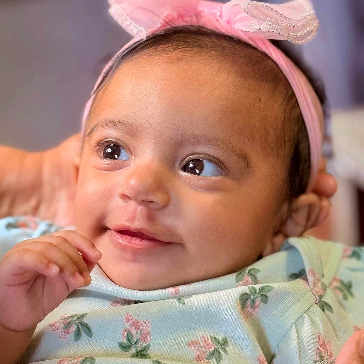 Zahrah is registered to the contest to win money with this photo: baby, infant, child, portrait, face, smiling, happy, pink_bow, headband, floral_dress, clothing, indoor, close_up, sitting, hand, eyes, looking_at_camera, caregiver, soft_lighting, adorable