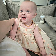 Ellie participe au concours pour gagner de l'argent avec cette photo : baby, child, smiling, dress, couch, indoor, bottle, happy, person, arm, home, infant, cute, sitting, necklace, furniture, portrait, light, skin, comfort