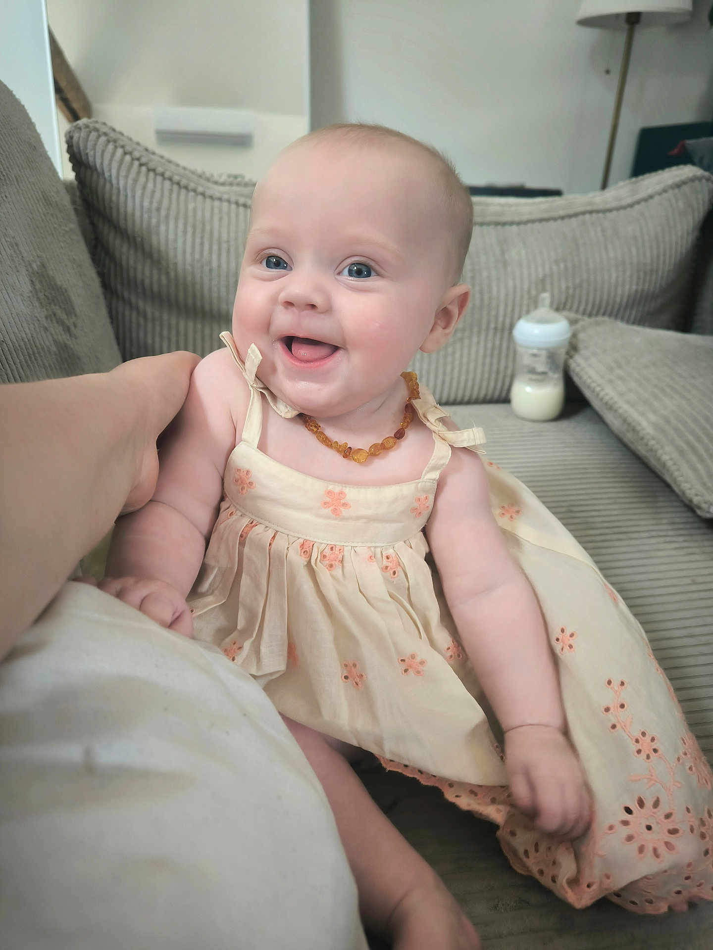 Ellie participe au concours pour gagner de l'argent avec cette photo : baby, child, smiling, dress, couch, indoor, bottle, happy, person, arm, home, infant, cute, sitting, necklace, furniture, portrait, light, skin, comfort