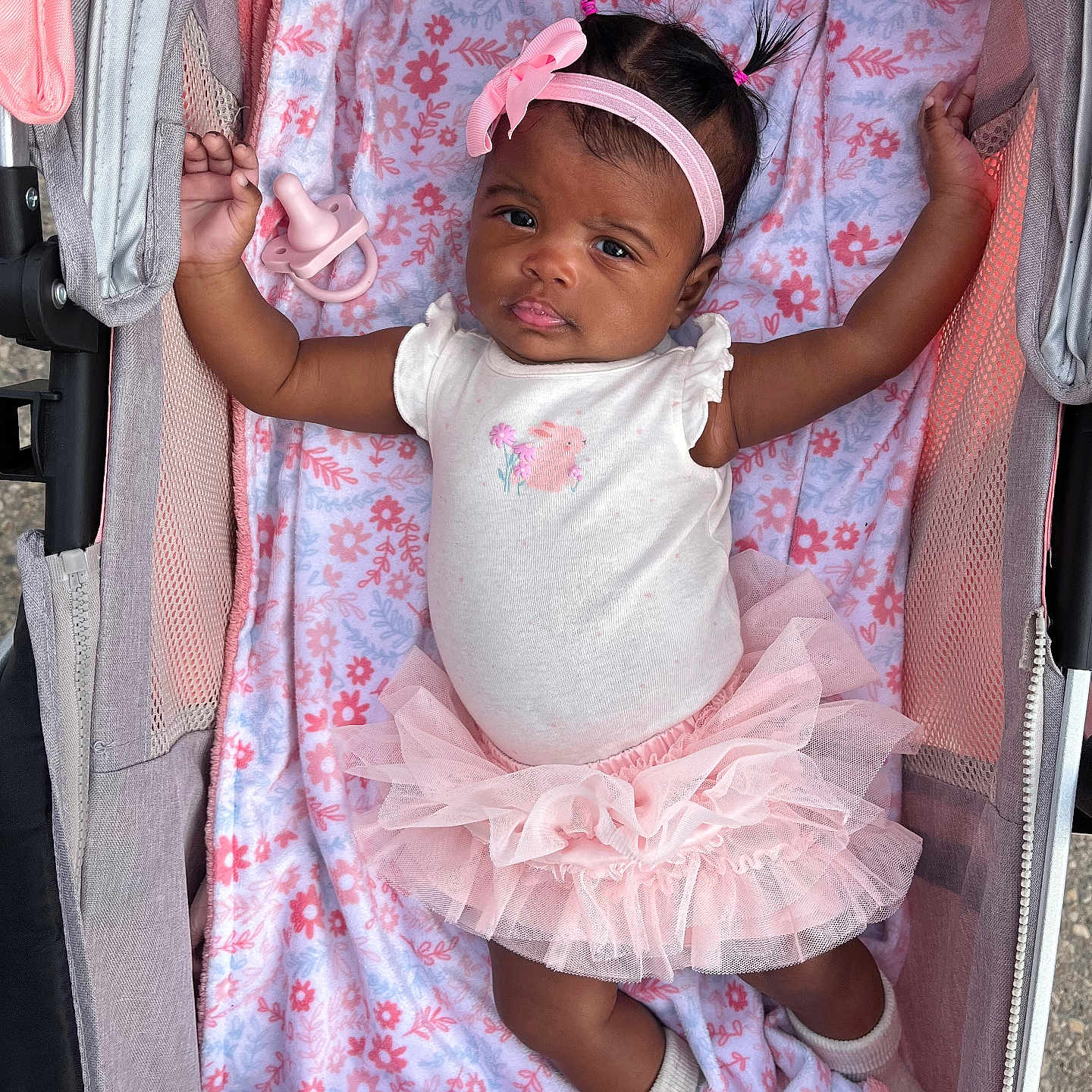 Parris is registered to the contest to win money with this photo: baby, baby_girl, blanket, bow, child, clothing, cute, expression, face, headband, infant, lying_down, outdoor, pacifier, pink, portrait, socks, soft_texture, stroller, tutu