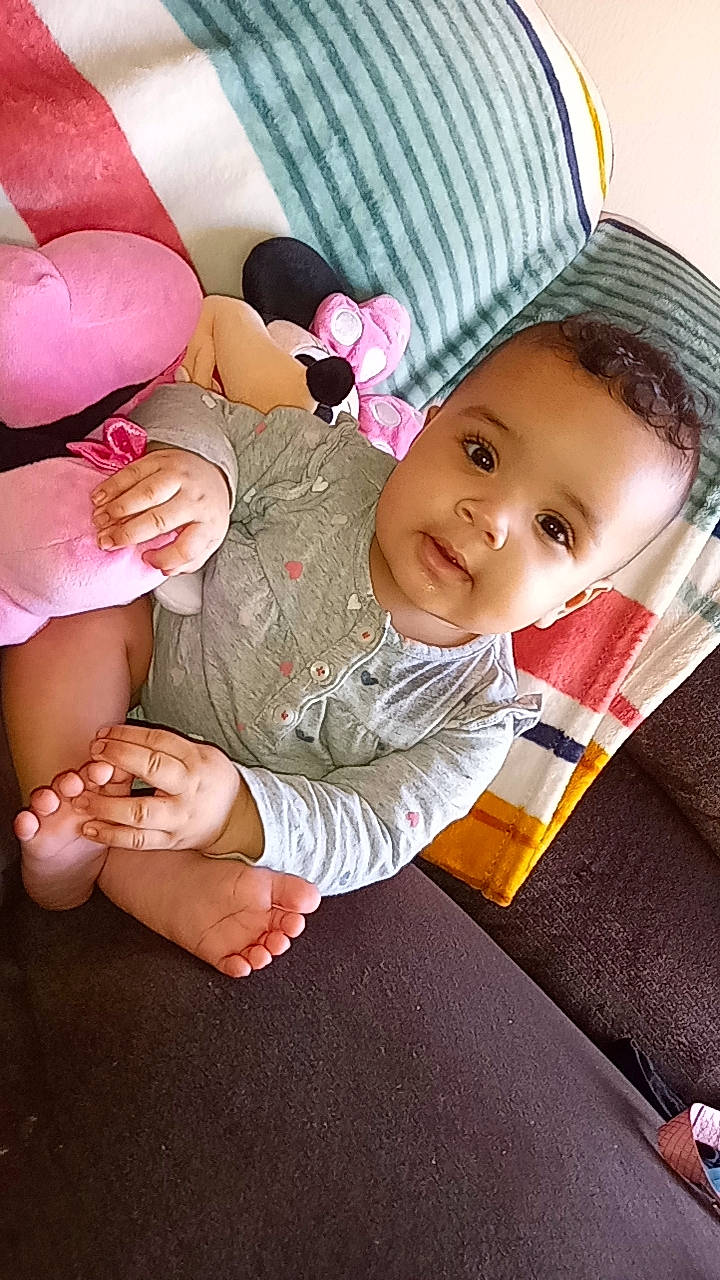 Emersyn is registered to the contest to win money with this photo: baby, comfort, dress, finger, foot, fun, gesture, happy, hat, head, headgear, human_body, human_leg, mouth, nose, person, skin, smile, thigh, thumb