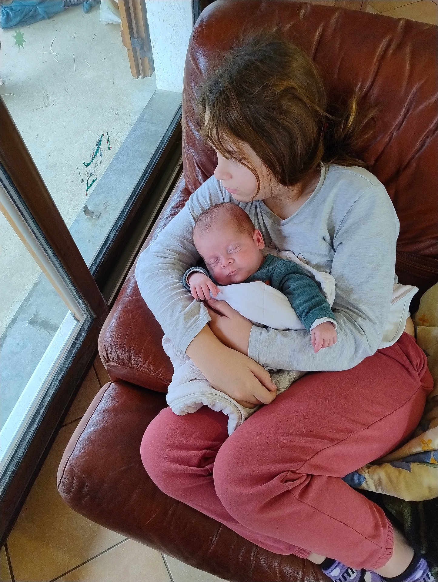 William a rejoint le concours — aidez-le/la à gagner de superbes lots ! child, baby, newborn, sleeping, holding, couch, chair, window, indoor, natural_light, family, tenderness, love, cozy, blanket, casual_clothing, person, young_child, sibling, relaxation