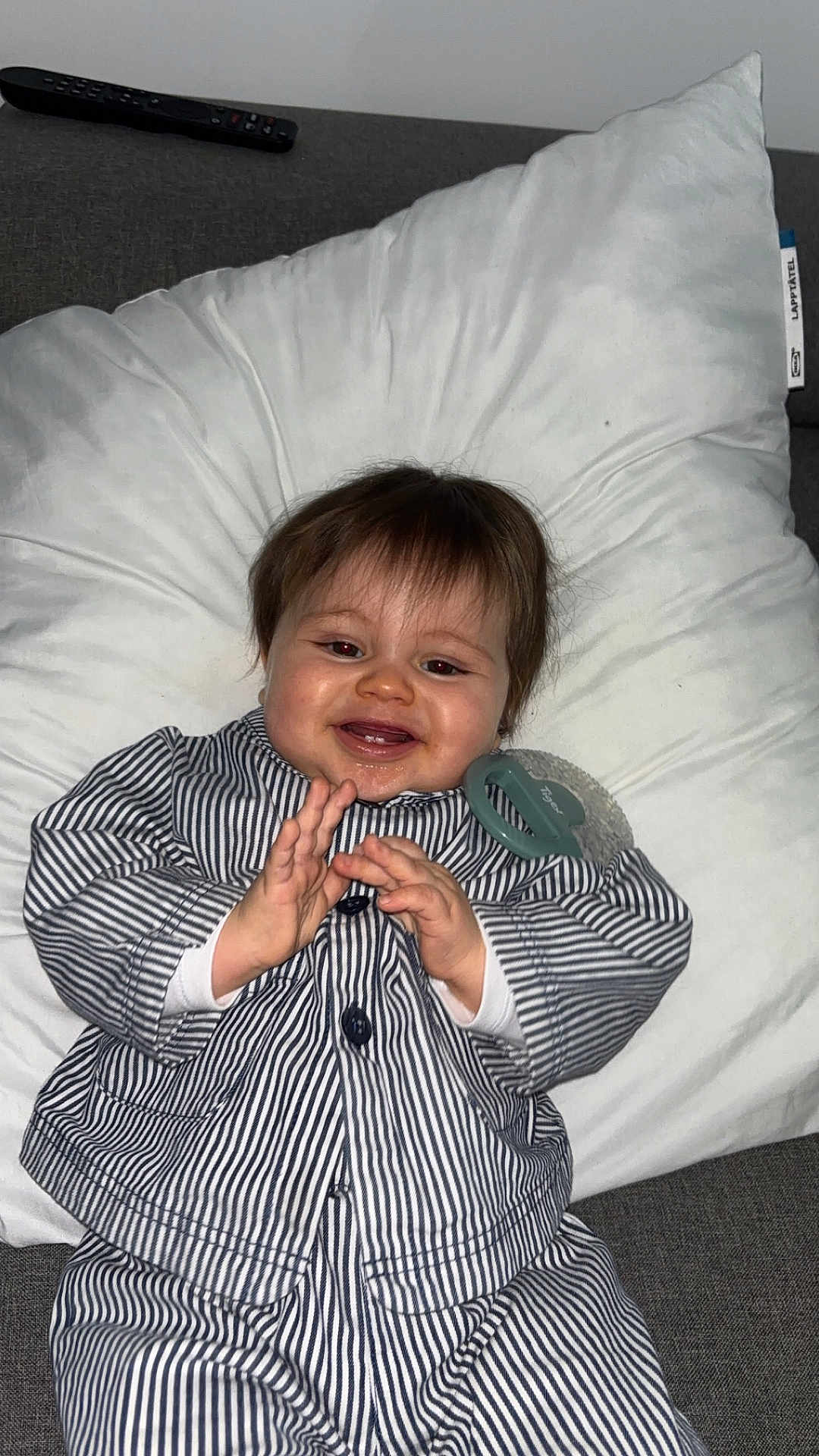 Zayn a rejoint le concours — aidez-le/la à gagner de superbes lots ! baby, infant, child, pillow, striped_pajamas, smiling, hands, pacifier, sofa, remote_control, hair, face, teeth, happy, indoor, drooling, clapping, portrait, clothing, cushion