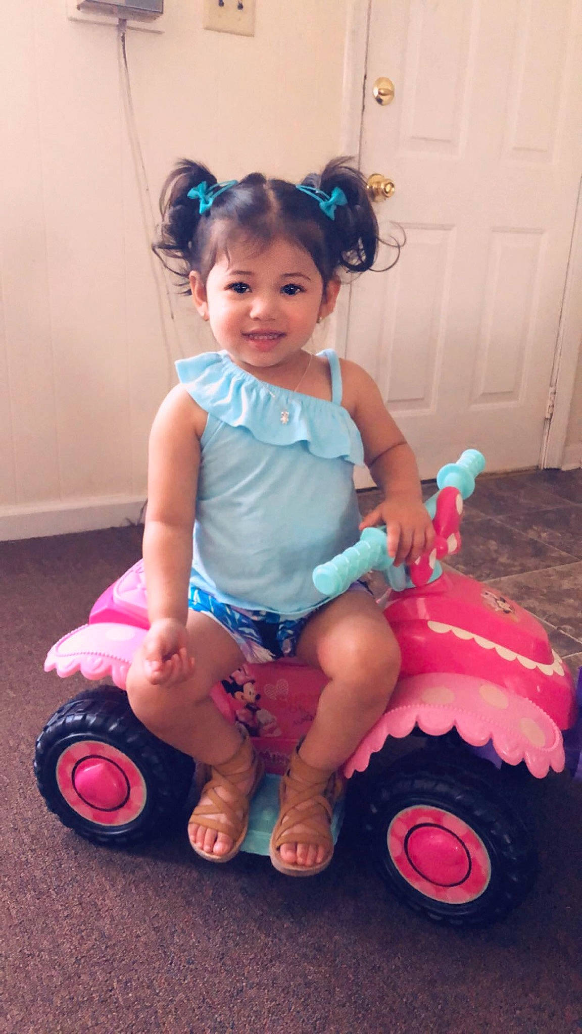 Angela is registered to the contest to win money with this photo: baby_products, baby_toddler_clothing, child, fun, happy, joy, person, pink, play, product, riding_toy, sitting, smile, toddler, toy, vehicle