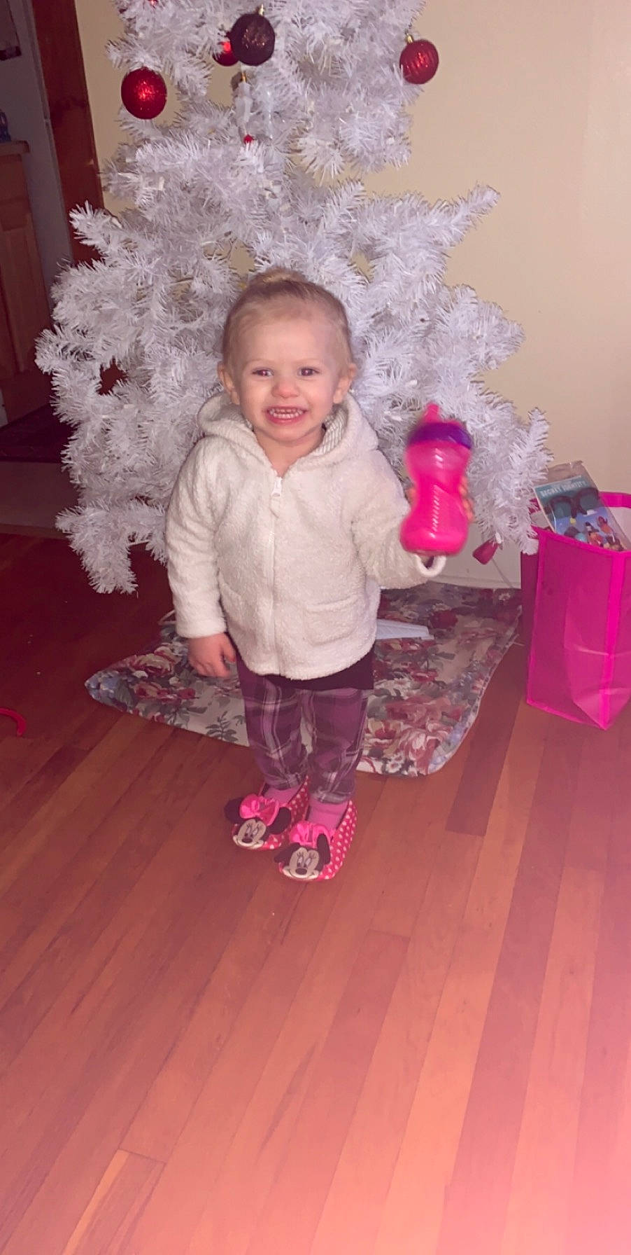 Violette is registered to the contest to win money with this photo: child, christmas, day, floor, flooring, fun, girl, holiday, infant, joy, person, petal, pink, play, product, red, sitting, skin, standing, textile