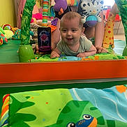 Athena a rejoint le concours — aidez-le/la à gagner de superbes lots ! adult, baby, child, colorful, crawling, cute, giraffe_toy, green, happiness, indoor, mirror, orange, pattern, person, phone, play_mat, purple, reflection, smiling, toys