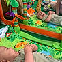 Athena participe au concours pour gagner de l'argent avec cette photo : baby, child, clothing, colorful, giraffe_plush, green, hand, indoor, infant, joyful, lying_down, mirror, orange, person, phone, play_mat, purple, reflection, smiling, toys