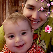 Athena participe au concours pour gagner de l'argent avec cette photo : baby, baby_girl, child, closeup, clothing, cute, face, flower_stickers, happy, hug, indoor, long_hair, playful, portrait, smile, table, warm_lighting, woman, wooden_background, young_woman