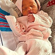 Goddess is registered to the contest to win money with this photo: newborn, baby, sleeping, infant, pink_clothing, blanket, cozy, soft_texture, face, closed_eyes, hand, cute, resting, indoors, portrait, child, human, peaceful, wrapped, warm