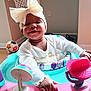 Nylah joined the competition — help win amazing prizes! baby, child, smile, headband, bow, walker, toy, ball, indoor, floor, wooden_floor, clothing, person, infant, cute, happy, playful, colorful, hand, face