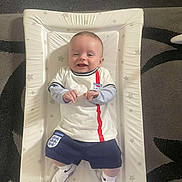 Ryder joined the competition — help win amazing prizes! baby, smiling, infant, changing_mat, clothing, sportswear, england, socks, indoor, carpet, happy, person, child, cute, portrait, laying_down, floor, star_pattern, sock, toddler