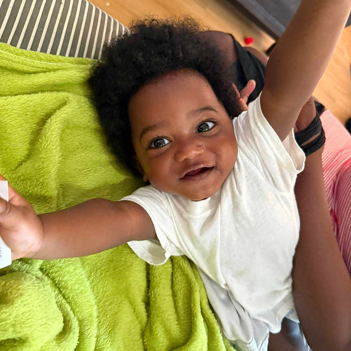 Shemar joined the competition — help win amazing prizes! arms_up, baby, child, curly_hair, cute, expression, face, green_blanket, happy, home, indoor, joy, person, playful, skin, smiling, striped_couch, toddler, white_shirt, wooden_floor