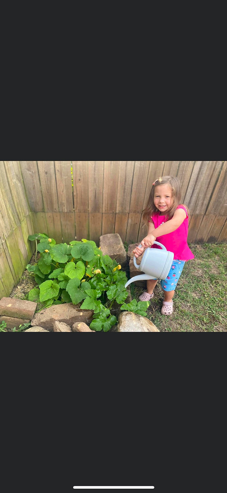Annie is registered to the contest to win money with this photo: annual_plant, boot, child, flash_photography, flower, fun, garden, grass, happy, joy, landscape, lawn, leisure, people_in_nature, person, plant, shorts, shrub, sitting, soil