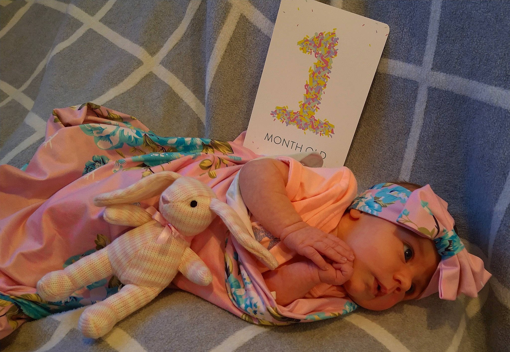 Bridgette is registered to the contest to win money with this photo: baby, baby_toddler_clothing, child, comfort, doll, fashion_accessory, hand, headwear, human_body, jewellery, knee, linens, pattern, peach, person, pink, room, stuffed_toy, textile, thigh