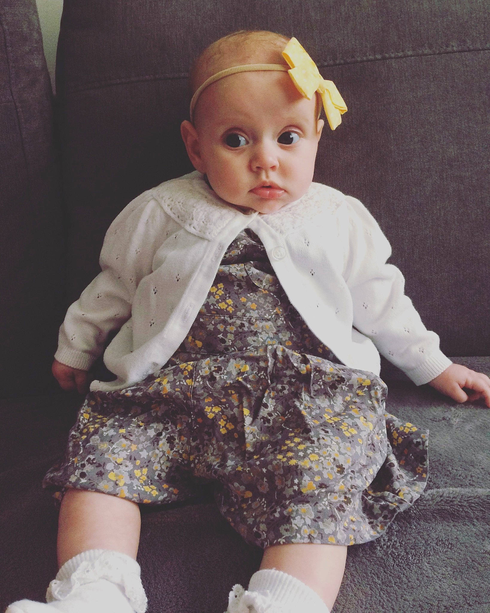 Grace is registered to the contest to win money with this photo: baby, beige, blond, cheek, child, doll, dress, head, joint, leg, outerwear, pattern, person, shoe, sitting, skin, sleeve, standing, toddler, toy