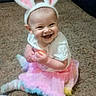 Emberlyn joined the competition — help win amazing prizes! baby, child, bunny_ears, tutu, carpet, smiling, happy, sitting, toy, playful, costume, cute, indoor, legs, feet, clothing, person, infant, joy, fun