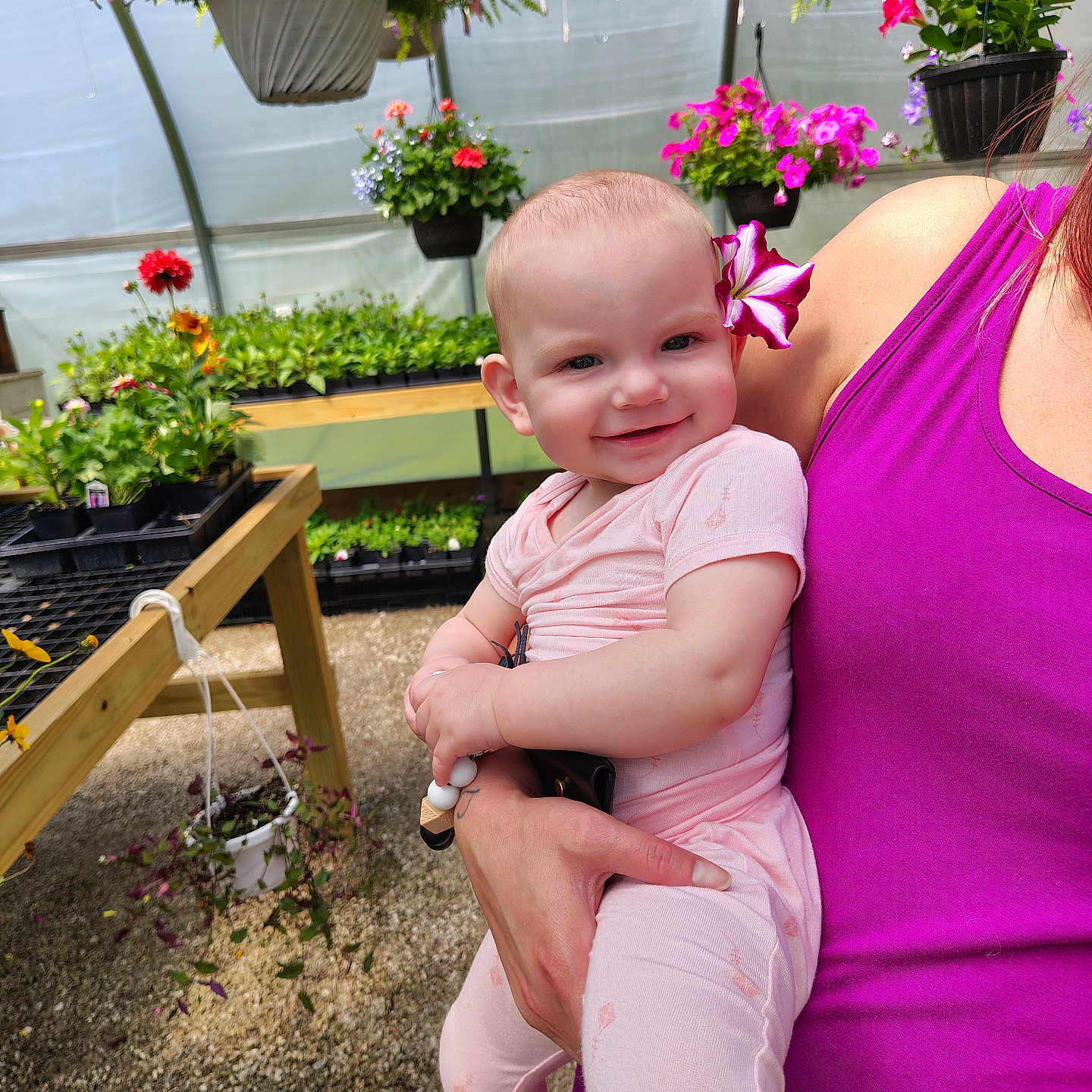 Emberlyn joined the competition — help win amazing prizes! baby, child, person, flower, greenhouse, plants, hanging_plants, potted_plants, pink_clothing, magenta_clothing, smiling, happy, indoor, nature, garden, holding, portrait, cute, infant, colorful