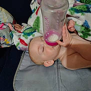 Emberlyn is registered to the contest to win money with this photo: baby, bottle, blanket, child, milk, sleeping, hand, face, skin, infant, bed, comfort, rest, young, peaceful, nurture, indoor, person, couch, clothing
