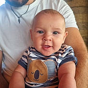 Ezéchiel participe au concours pour gagner de l'argent avec cette photo : baby, man, beard, smiling, holding, indoor, striped_shirt, koala_patch, white_tshirt, portrait, happy, child, person, closeup, arm, casual_clothing, face, infant, seated, family