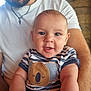 baby, man, beard, smiling, holding, indoor, striped_shirt, koala_patch, white_tshirt, portrait, happy, child, person, closeup, arm, casual_clothing, face, infant, seated, family