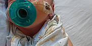 Remington is registered to the contest to win money with this photo: baby, newborn, pacifier, blanket, animal_print, sleeping, face, arm, bed, person, infant, skin, comfort, rest, cute, child, hospital, medical_tape, closeup, peaceful