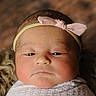 newborn, baby, headband, pink_bow, blanket, closeup, portrait, soft_texture, sleepy, infant, cute, cozy, wrapped, face, skin, child, young, resting, indoors, warm