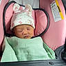 newborn, baby, sleeping, car_seat, pink, mint_green, blanket, hat, ears, bows, seatbelt, infant, child, cute, peaceful, resting, face, clothing, indoors, portrait