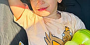 Colby is registered to the contest to win money with this photo: toddler, child, car_seat, sippy_cup, shirt, red_glasses, sunlight, hair_tie, seatbelt, cute, smiling, casual_clothing, indoor, young_child, playful, hand, face, expression, seat, safety