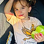 toddler, child, car_seat, sippy_cup, shirt, red_glasses, sunlight, hair_tie, seatbelt, cute, smiling, casual_clothing, indoor, young_child, playful, hand, face, expression, seat, safety