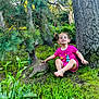 Colby is registered to the contest to win money with this photo: child, toddler, grass, tree, garden_statue, deer, pink_clothing, barefoot, outdoor, nature, greenery, plants, tree_trunk, smiling, playful, sunlight, shadows, garden, foliage, happy