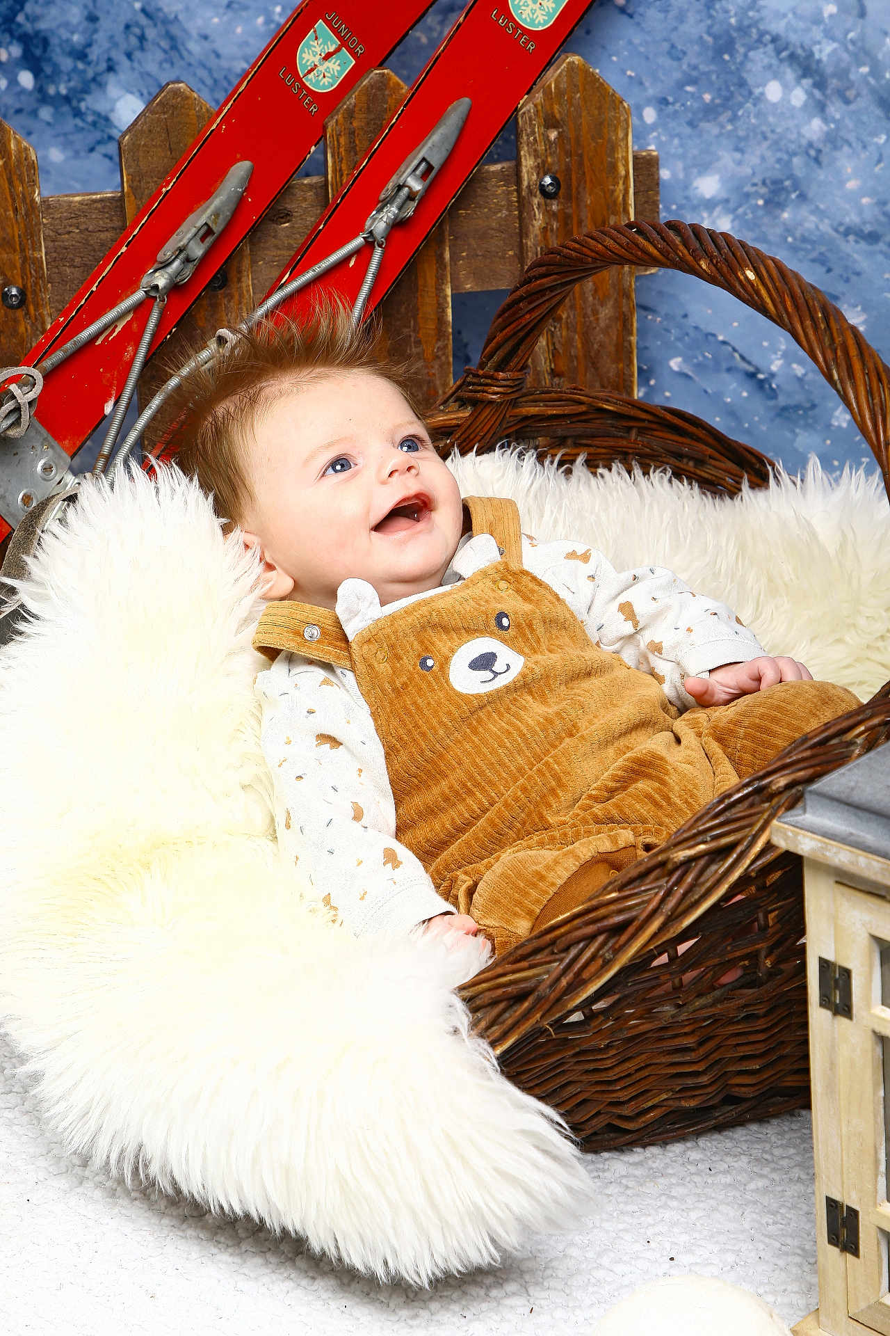 Lyor participe au concours pour gagner de l'argent avec cette photo : baby, infant, wicker_basket, fur_blanket, brown_overalls, bear_design, smiling, blue_eyes, rustic, wooden_skis, winter_theme, cozy, fluffy, cute, portrait, indoor, child, happy, clothing, photography