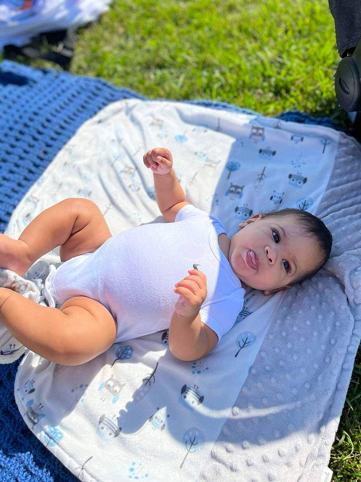 Romeo is registered to the contest to win money with this photo: baby, baby_toddler_clothing, blue, child, comfort, foot, fun, grass, green, happy, human_leg, lap, leisure, person, product, recreation, sitting, smile, thigh, toddler