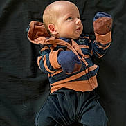 Luca joined the competition — help win amazing prizes! baby, infant, striped_hoodie, mittens, black_pants, bare_foot, lying_down, curious_expression, face, head, clothing, child, young, portrait, indoor, person, cute, small, newborn, apparel