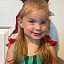 apparel, blue_eyes, child, childhood, cute, door, face, fashion, girl, green_dress, hair, happy, indoor, long_hair, person, portrait, red_bow, ribbon, smile, young