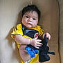 Jeannine joined the competition — help win amazing prizes! baby, infant, yellow_clothing, sports_jersey, socks, blue_bow, cushion, face, hands, legs, indoor, person, child, cute, portrait, soft_light, expression, home, comfort, closeup