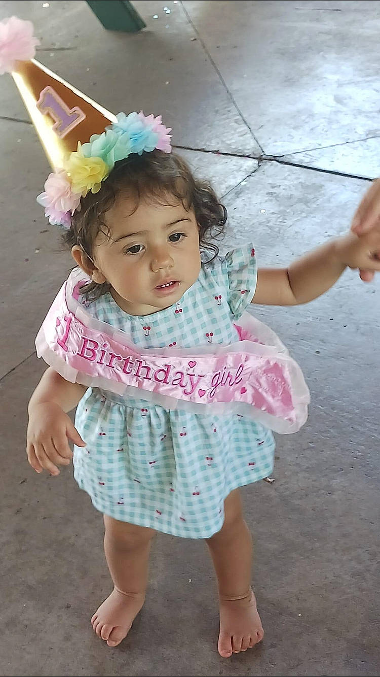 Lila joined the competition — help win amazing prizes! baby_toddler_clothing, child, costume, costume_hat, face, fashion_accessory, fun, happy, human_leg, magenta, party_hat, pattern, person, pink, play, sitting, skin, sleeve, smile, toddler