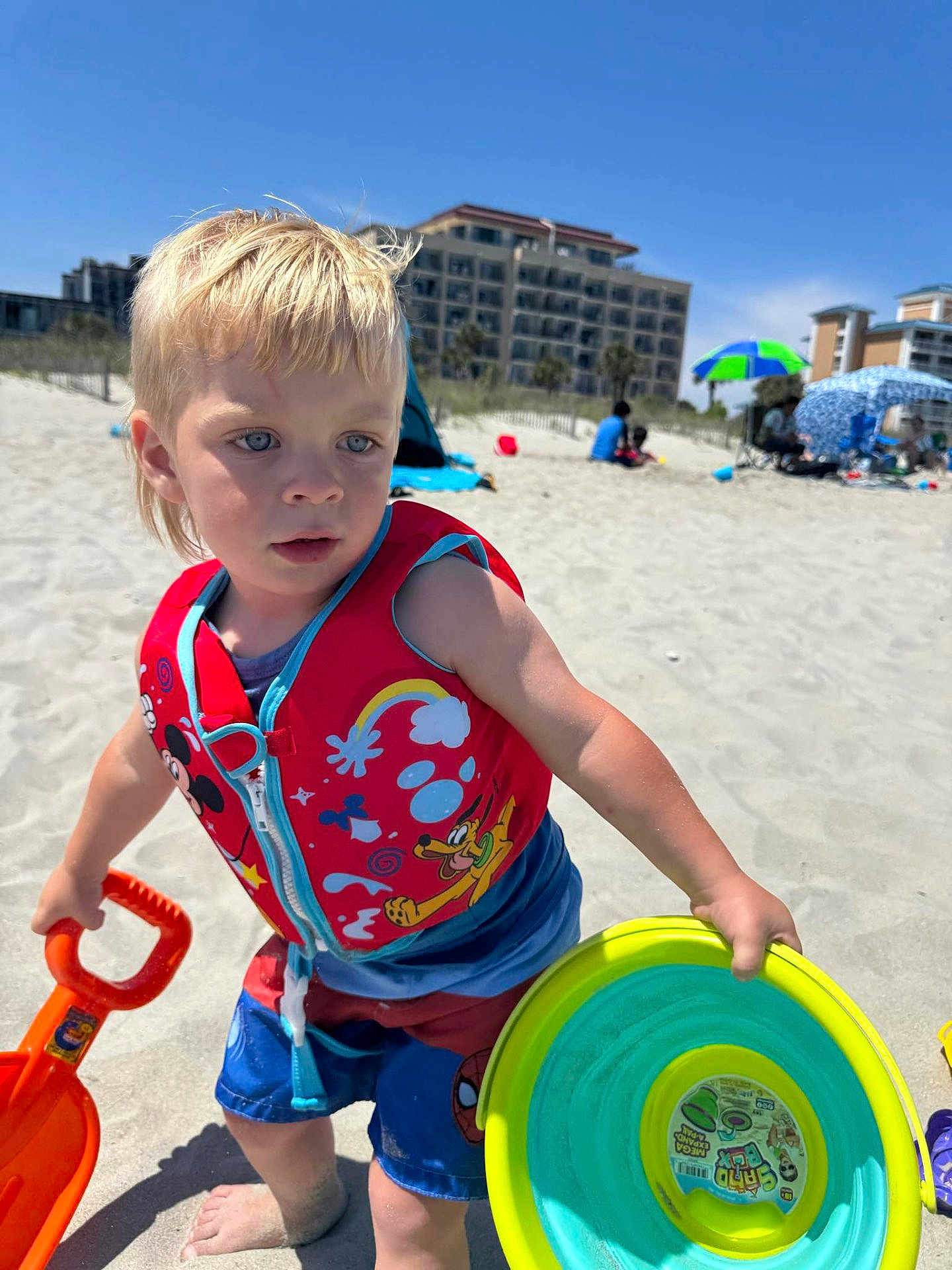 Sawyer joined the competition — help win amazing prizes! child, toddler, beach, sand, shovel, frisbee, life_vest, sunny, blue_sky, shorts, barefoot, toy, outdoor, vacation, summer, building_sandcastles, playing, colorful, water_toys, daytime