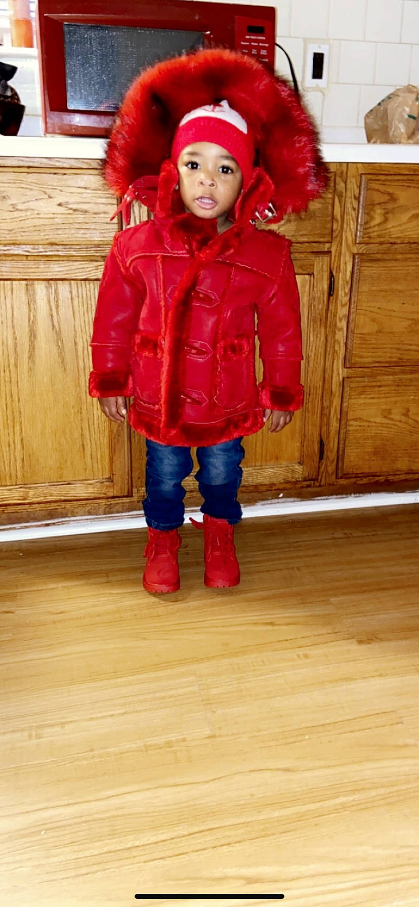 Davion joined the competition — help win amazing prizes! child, child_model, clothing, coat, footwear, fur, hood, jacket, jeans, leather_jacket, outerwear, parka, person, red, standing, toddler