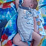 baby, sleeping, onesie, pacifier, striped_clothing, cartoon_character, tie_dye_blanket, colorful, soft_fabric, infant, peaceful, cute, child, lying_down, nap, comfort, skin, foot, hand, head