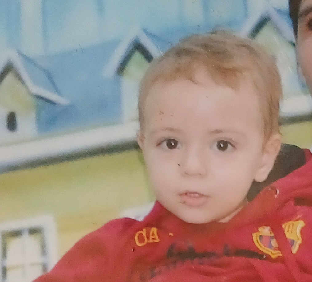 Mayas participe au concours pour gagner de l'argent avec cette photo : child, face, young_child, red_hoodie, portrait, indoor, curious_expression, light_brown_hair, person, closeup, background, colorful, painting, house, window, hoodie, casual_clothing, baby, kid, cute