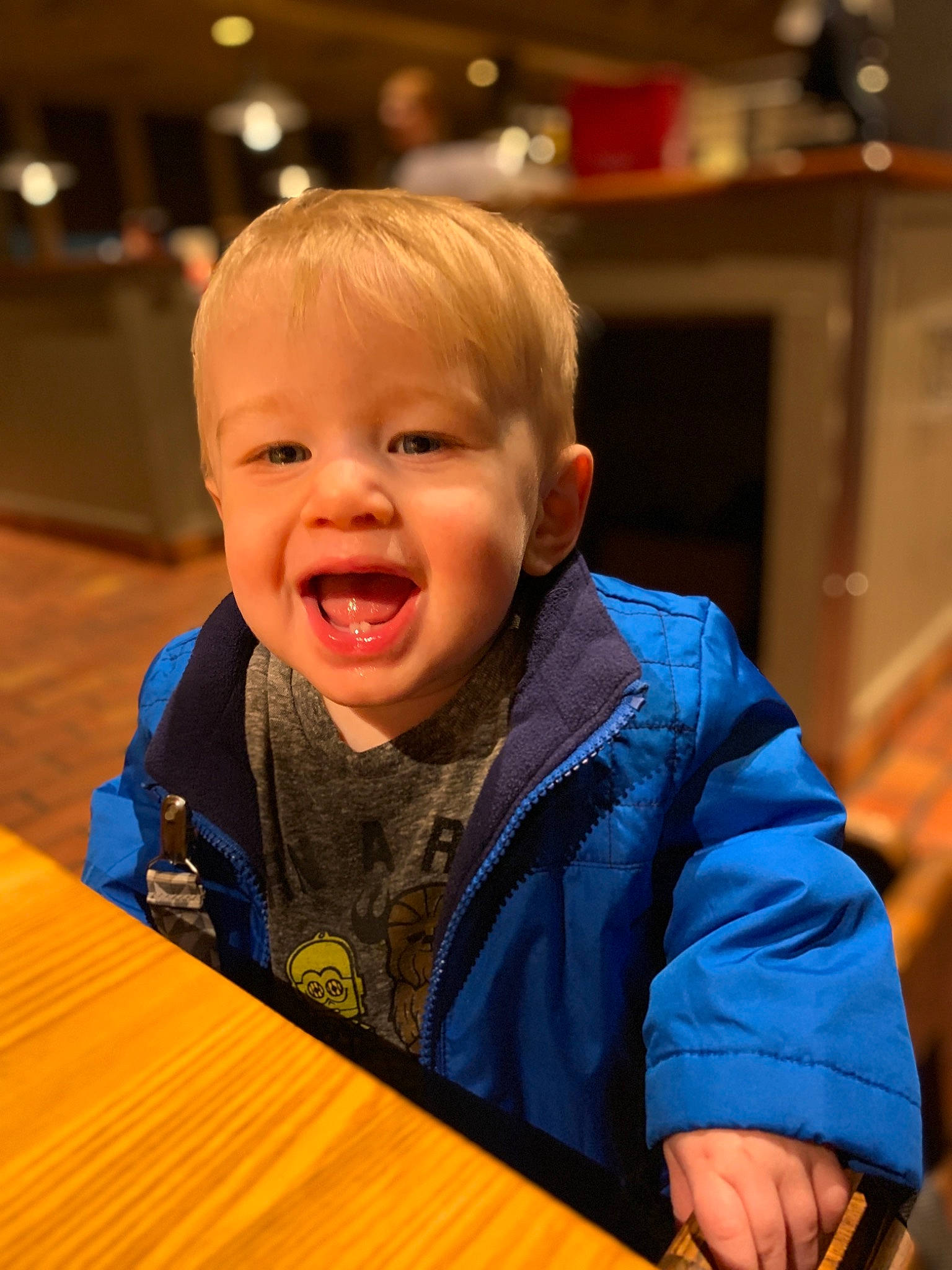 Finnegan is registered to the contest to win money with this photo: baby, cheek, child, face, facial_expression, fun, head, laugh, person, sitting, smile, toddler, wood