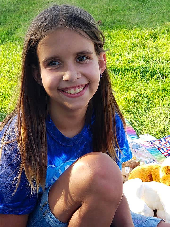 Holly is registered to the contest to win money with this photo: beauty, brown_hair, child, child_model, fun, grass, hair, happy, joy, leisure, long_hair, person, picnic, recreation, sitting, smile, summer, vacation