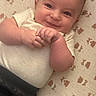 Brian joined the competition — help win amazing prizes! baby, child, infant, smiling, happy, face, portrait, lying_down, blanket, bed, teddy_bear_pattern, white_clothing, hands, arms, brown_eyes, indoors, close_up, candid, cute, family_photo