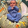 Brian is registered to the contest to win money with this photo: baby, infant, child, smiling, sitting, onesie, blue_clothing, blanket, colorful_blanket, baby_bouncer, indoor, portrait, face, hands, feet, nursery, carpet, shoes, baby_toys, home