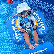 Wesson is registered to the contest to win money with this photo: baby, pool, float, sunglasses, hat, water, blue, red_flamingo, baby_float, child, summer, outdoor, safety_harness, swimming_pool, infant, relaxing, sun_protection, footrest, toy, cute