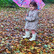 Tiana participe au concours pour gagner de l'argent avec cette photo : child, girl, umbrella, raincoat, forest, autumn, leaves, boots, smile, outdoor, nature, playful, pink, rainy_day, happy, standing, young, cute, seasonal, weather