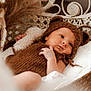baby, infant, knitted_clothing, brown, bear_hat, wicker_chair, soft_texture, blanket, cute, portrait, indoors, newborn, child, cozy, resting, hand, face, headwear, warm, relaxed