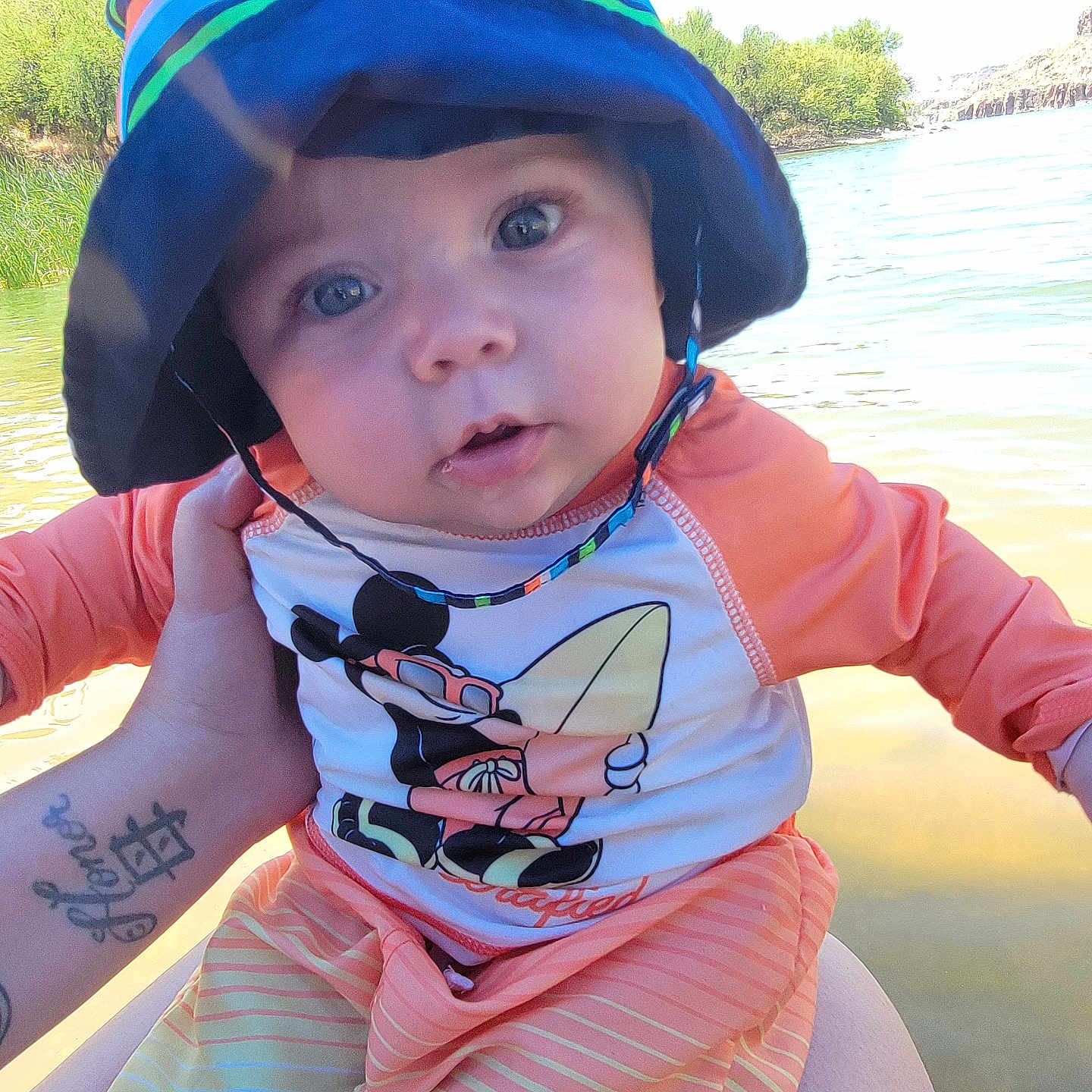 Malik is registered to the contest to win money with this photo: baby, baseballcap, cap, clothing, face, hat, head, helmet, lifejacket, nature, outdoors, person, photography, portrait, sea, skin, summer, t_shirt, tattoo, vest