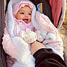 baby, infant, car_seat, blanket, pink, mittens, smiling, face, person, cute, warm_clothing, hood, hand, cozy, outdoor, child, apparel, happy, portrait, newborn