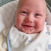 Archie is registered to the contest to win money with this photo: baby, smiling, bib, clothing, infant, face, child, cute, happy, seat, cushion, soft, indoor, portrait, young, small, toddler, comfort, wearing, closeup